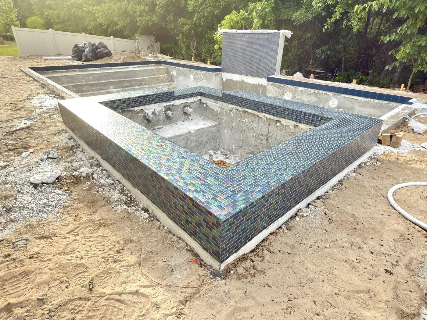 Blue mosaic tile around a raised spa