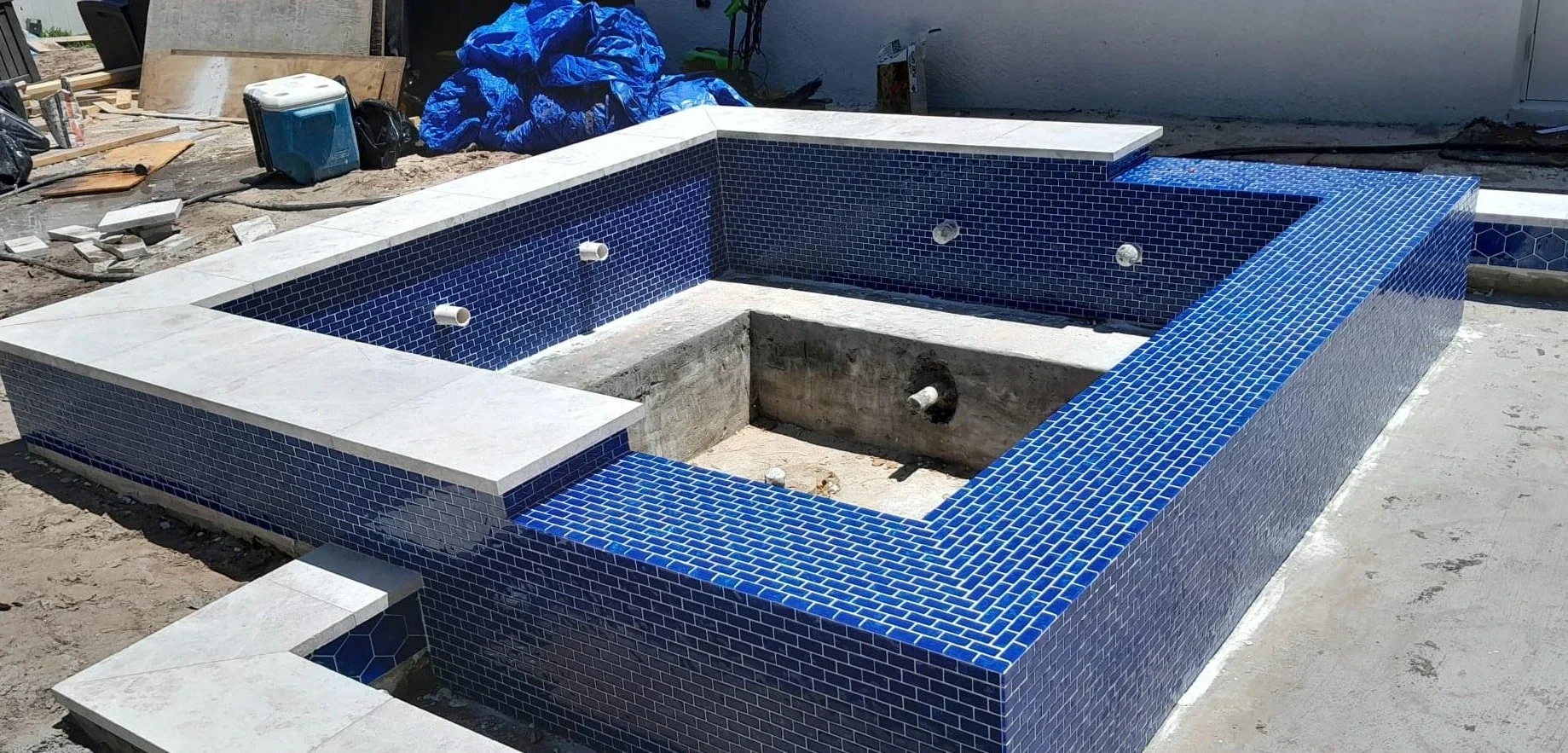 Rebuilt spa with blue mosaic tile and stone coping